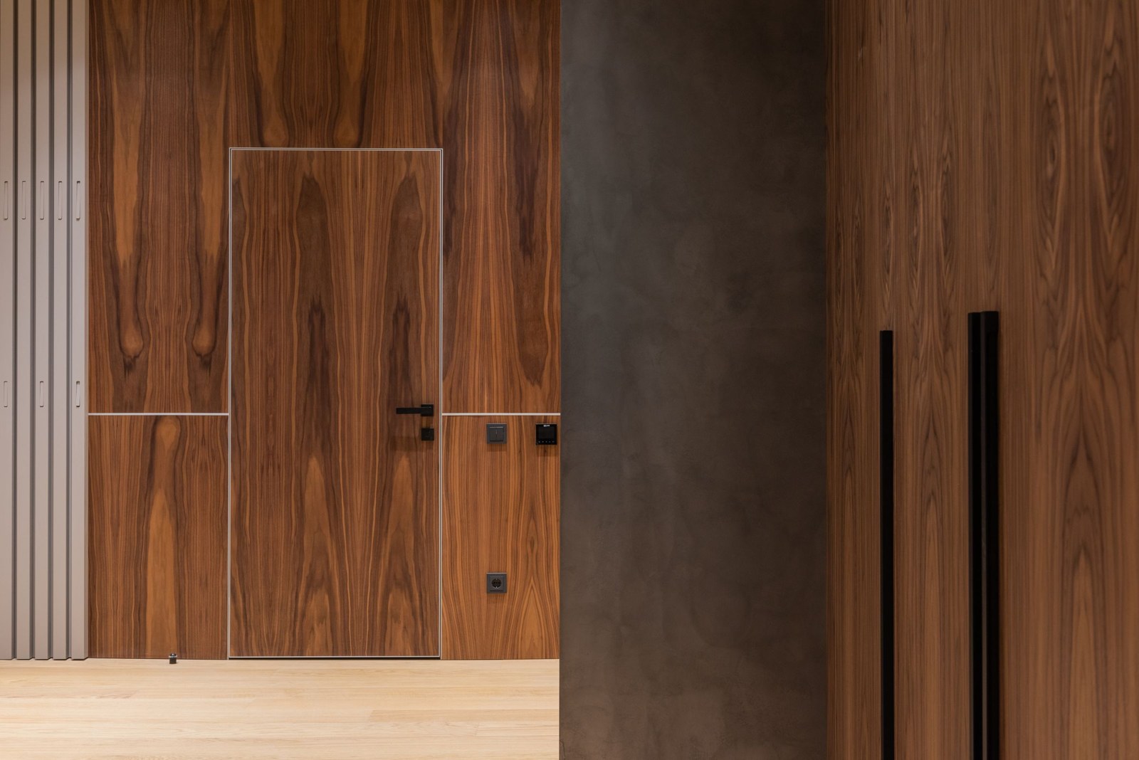 Puerta integrada a un revestimiento de madera en el acceso de una vivienda