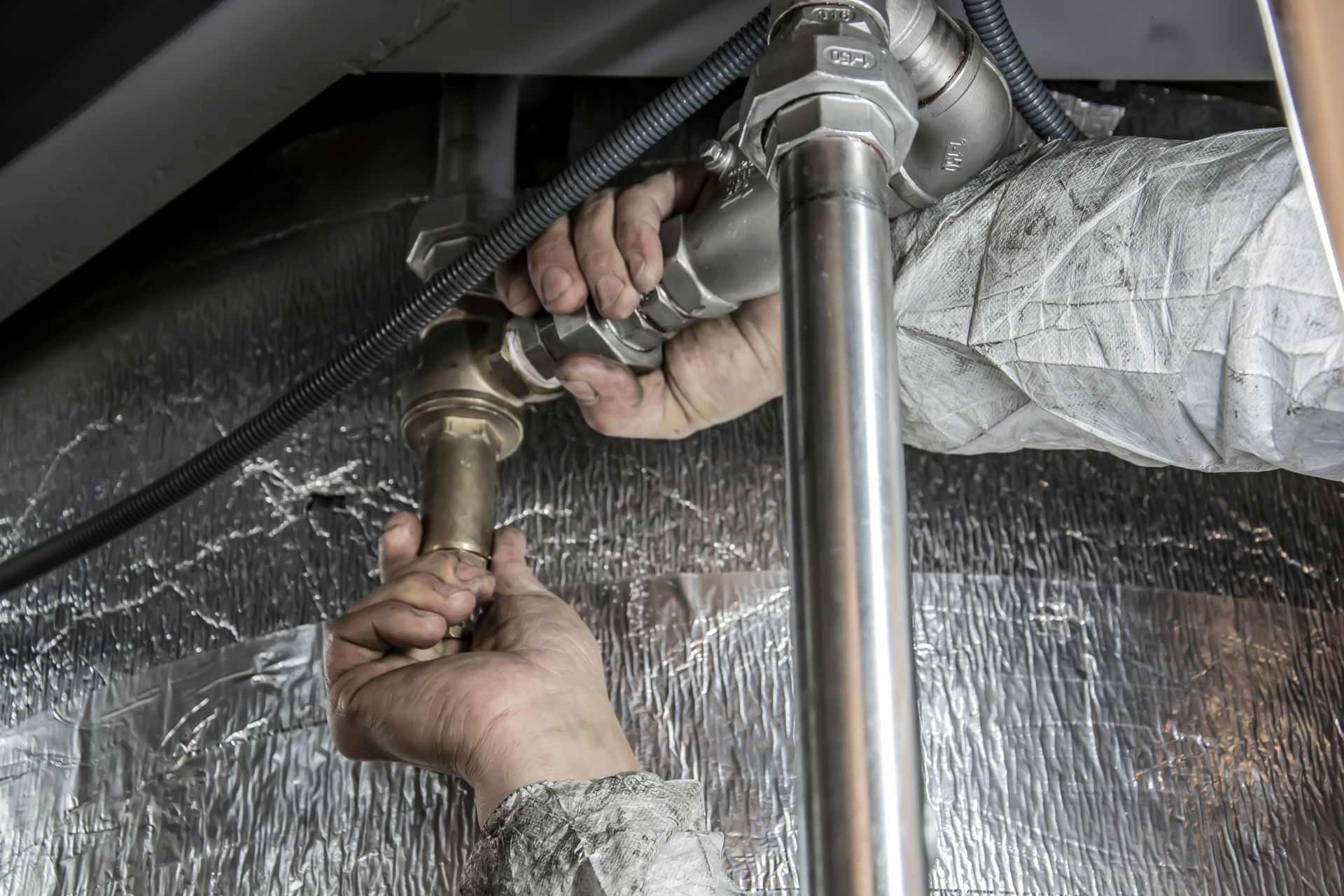 Manos de técnico ajustando una instalación de cañerías