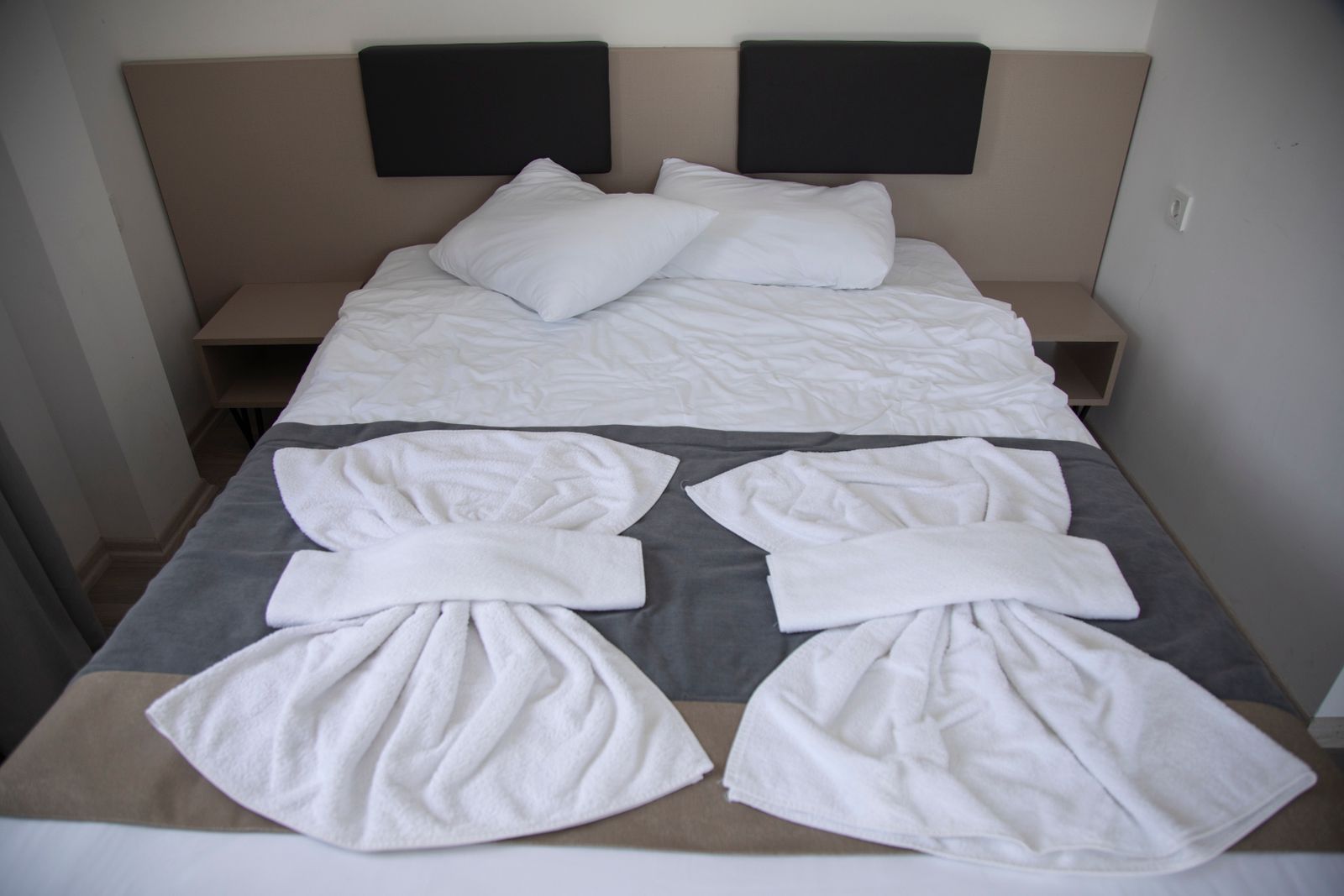 Cama preparada con blancos y toallas repuestos para la próxima llegada