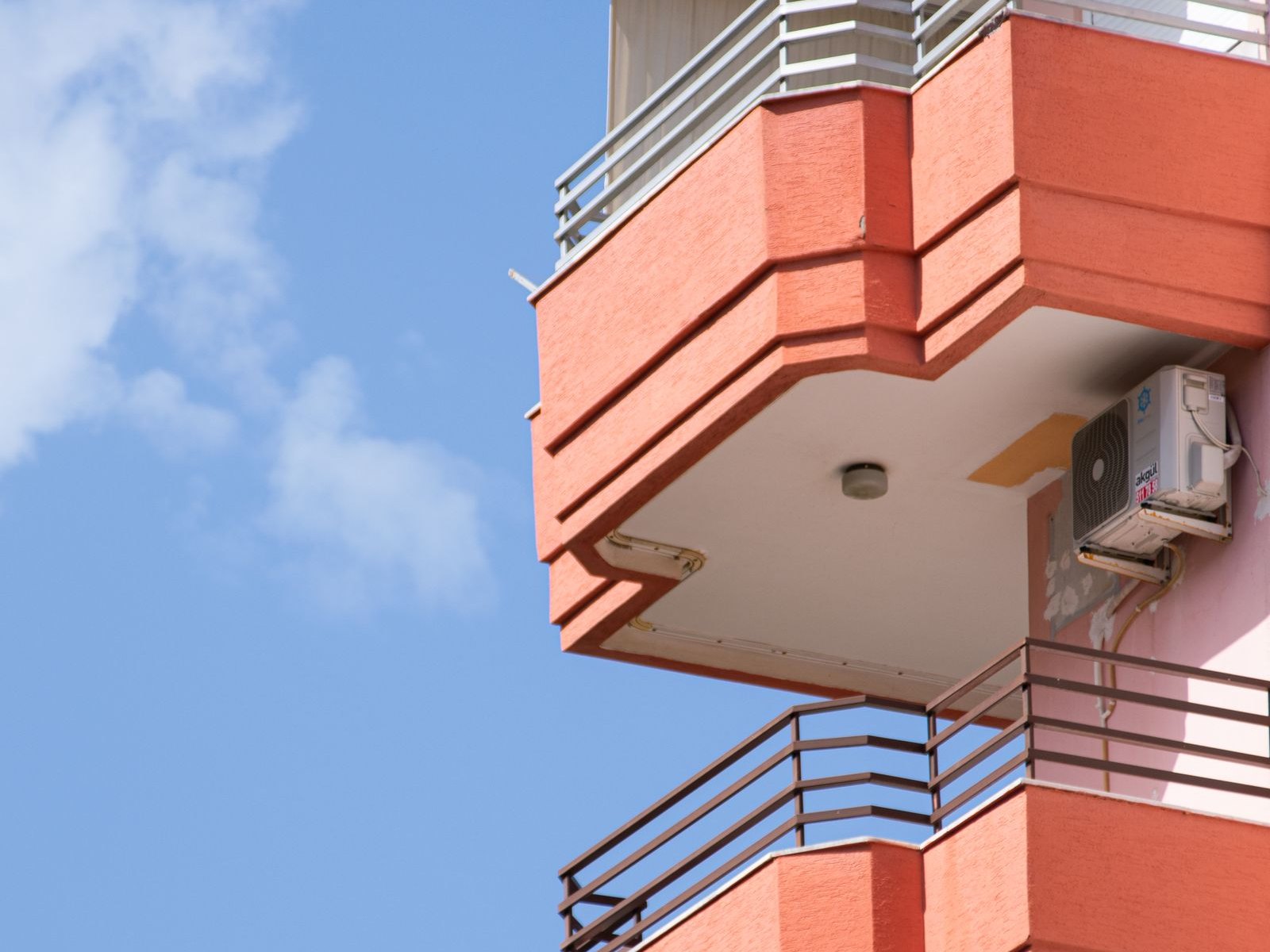 Fachada de un edificio residencial con balcones y equipos de aire acondicionado