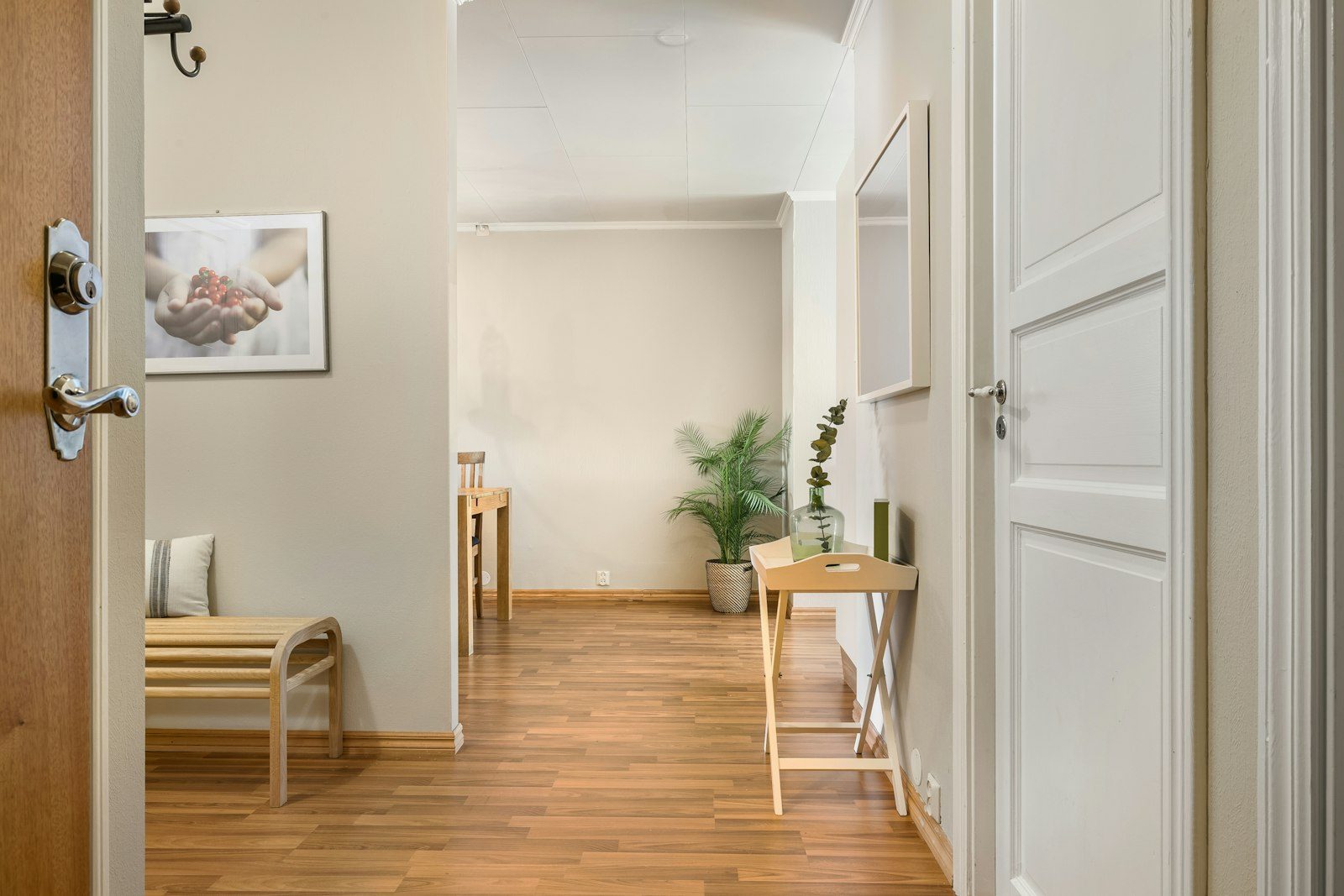 Entrada interior de una vivienda con una pared visible junto a la puerta