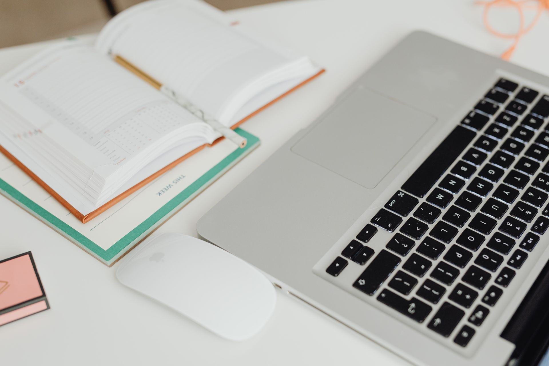 Agenda abierta y notebook sobre un escritorio para planificar fechas